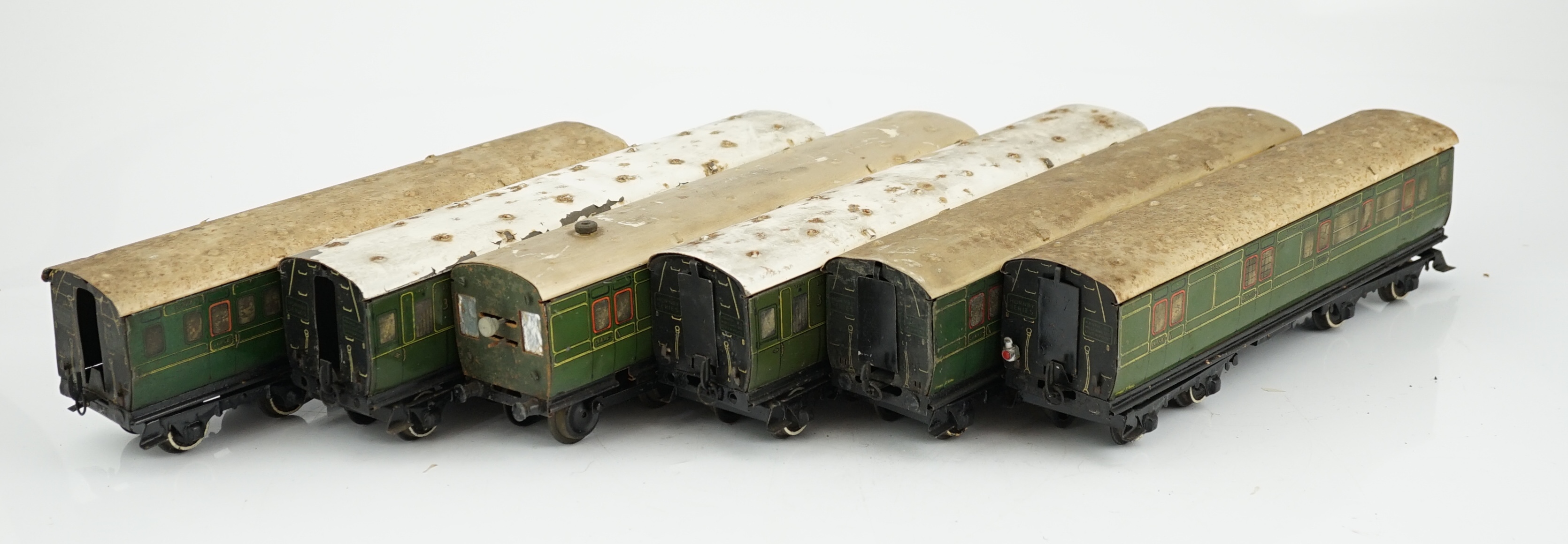 Six Hornby 0 gauge tinplate No.2 coaches in Southern Railway livery, one coach adapted to a driving unit with clockwork motor and replacement bogie